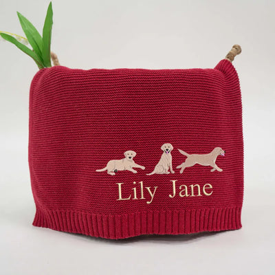 Red personalized baby blanket with labrador retrievers and 'Lily Jane' text on a white background