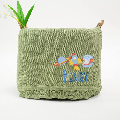 Sage green personalized baby blanket with rocket space ship design and 'HENRY' embroidery on a white background