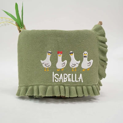 Sage green personalized baby blanket with embroidered geese and 'Isabella' text on a white background